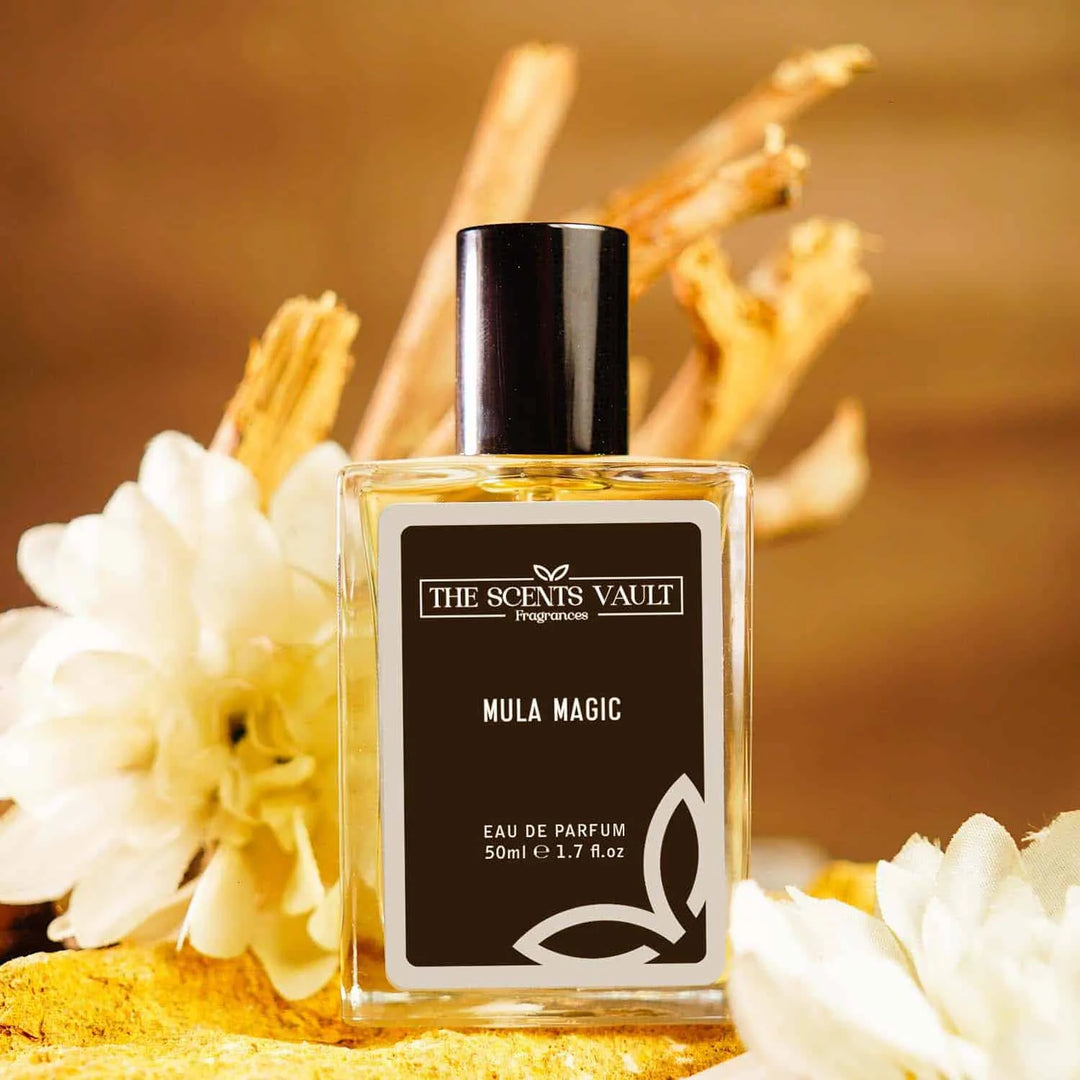 Mula Magic Eau de Parfum (50ml) from The Scents Vault, set against a backdrop of wooden sticks and white flowers.