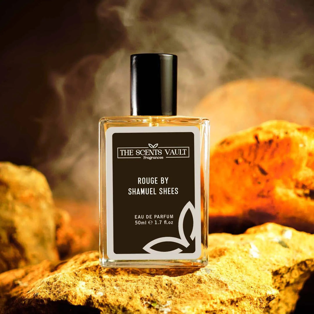 Rouge by Shamuell Shees Eau de Parfum (50ml) from The Scents Vault, displayed with a smoky backdrop and rocks in the background.