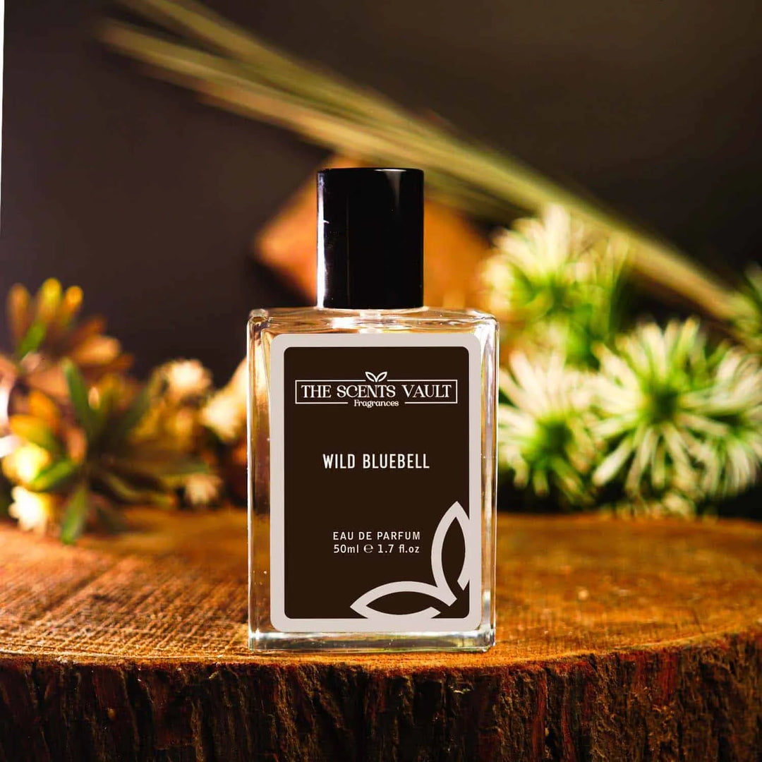 Wild Bluebell perfume by The Scents Vault placed on a wooden surface with pine and greenery in the background.