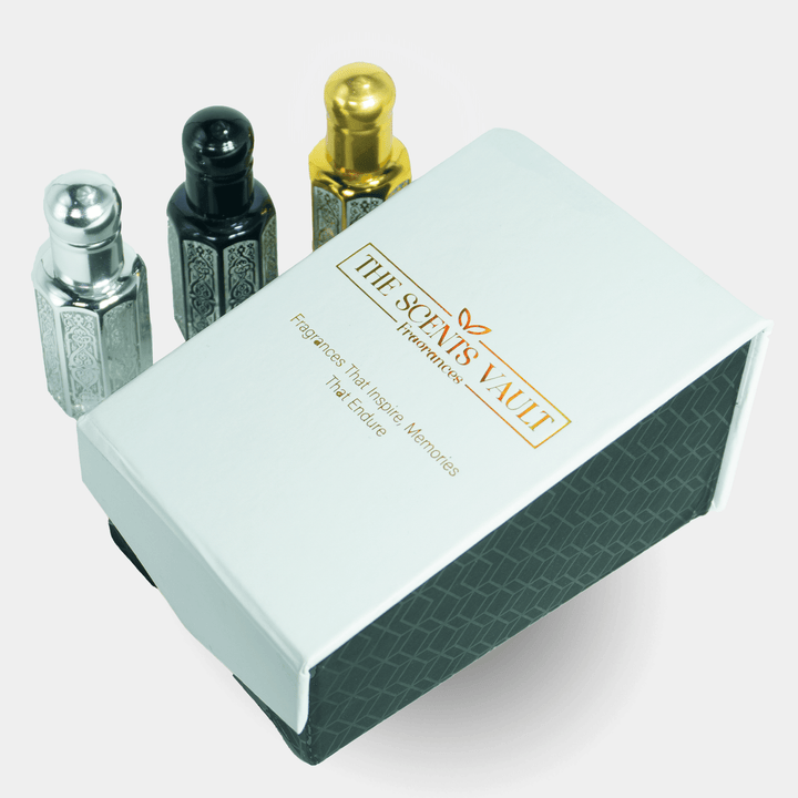 Three perfume bottles with metallic caps on a white box labeled 'The Scents Vault' against a white background.