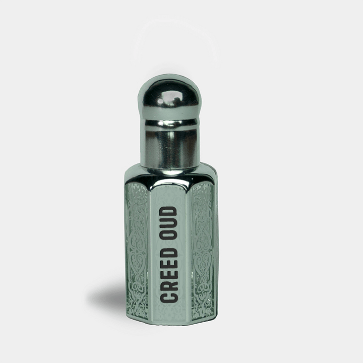 Perfume bottle labeled 'Creed Oud' with silver cap on a light gray background 12ml